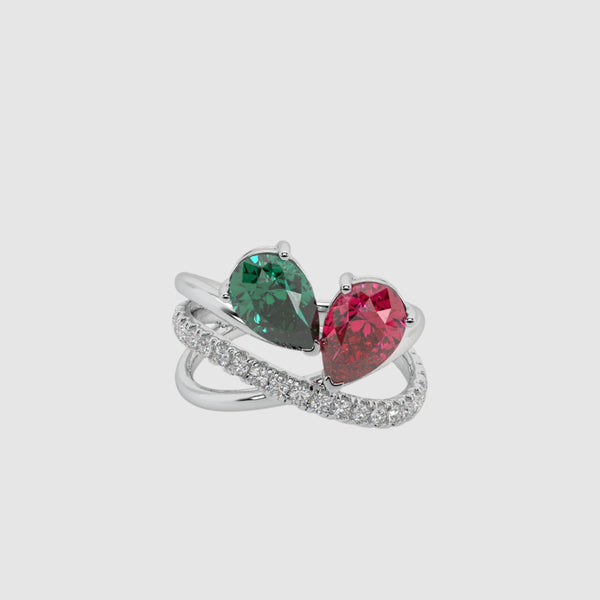 Silver ring with green and red gemstones on a white background